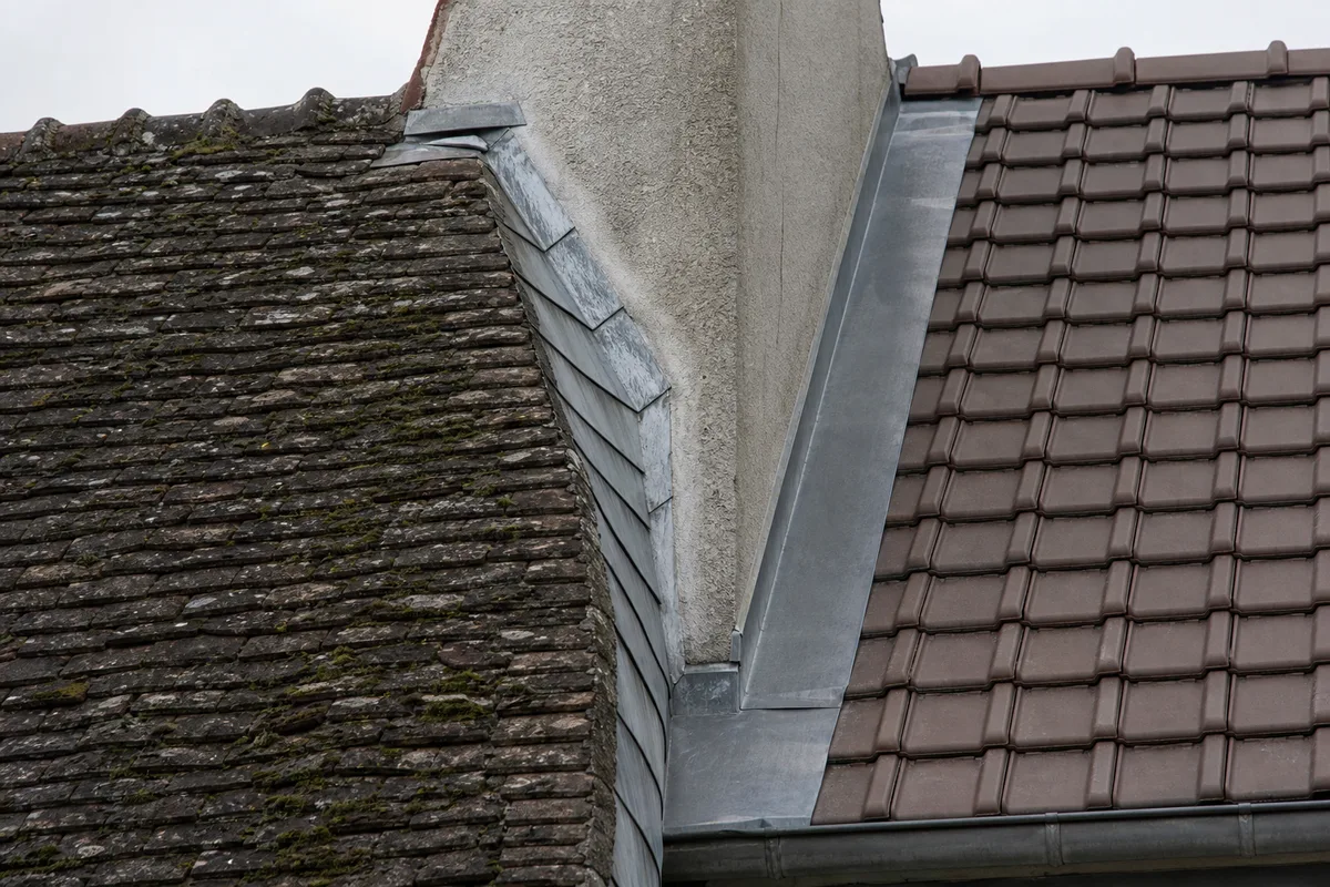 Toitures mitoyennes de maisons de ville dans les Hauts-de-Seine, versants en tuile plate séparés par un mur pignon
